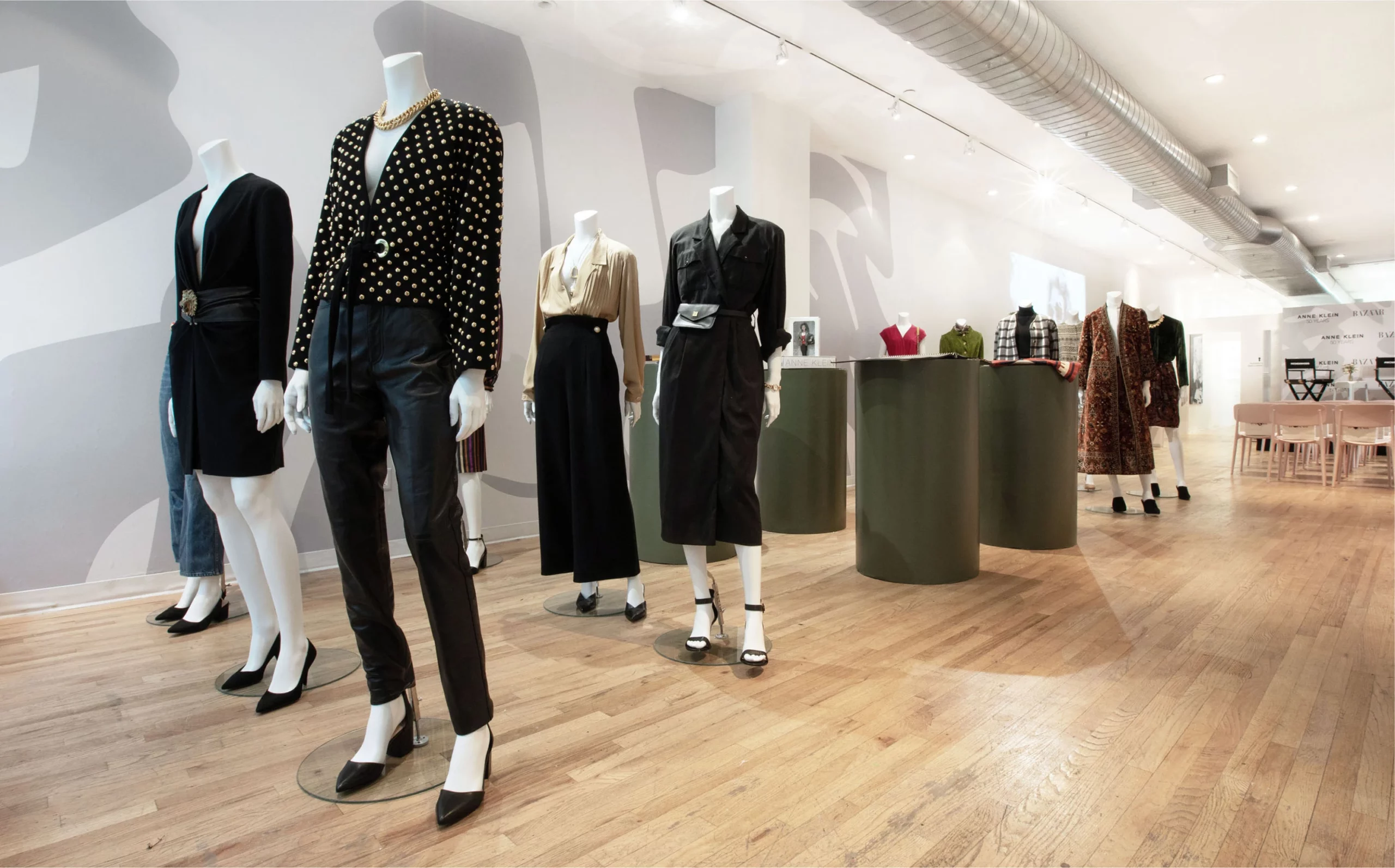Anne Klein pop up shop showroom floor showing various manicans and garments with light wood floor and white walls