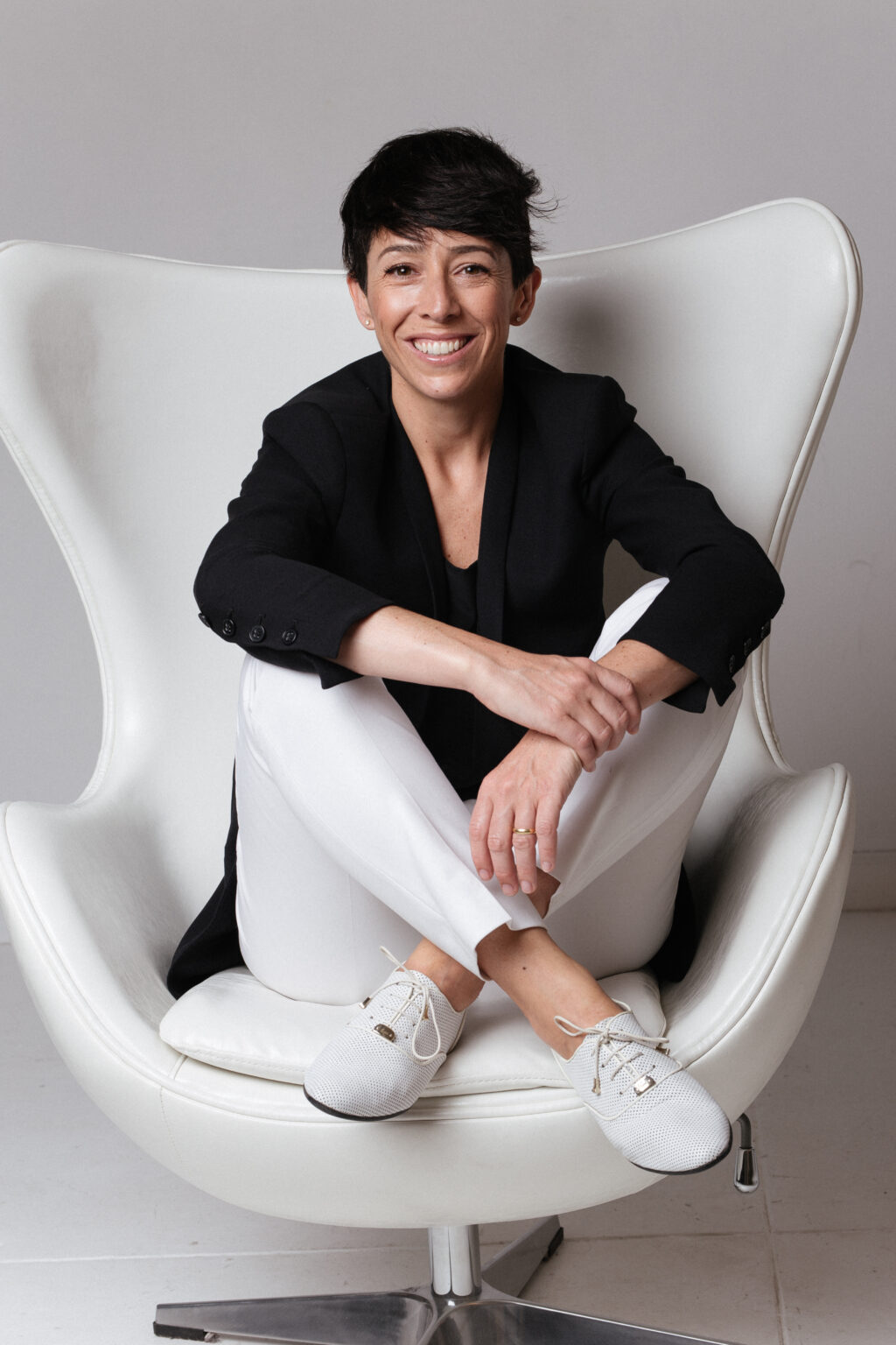 Gala Magrina in a modern chair wearing black and white